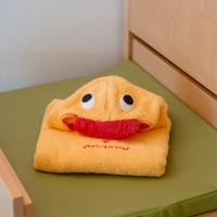 Ein gelbes Kinderhandtuch, liebevoll als Ente mit großen, aufgenähten Augen und rotem Schnabel gefaltet, liegt auf einer grünen Wickelauflage. Das Handtuch sorgt für fröhliche Stimmung und eignet sich ideal für Familien mit kleinen Kindern.