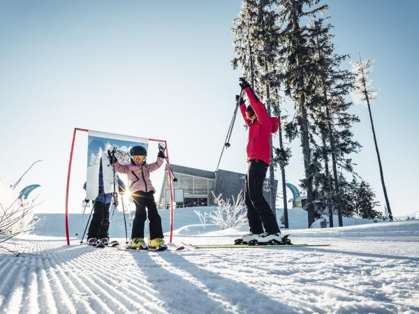 2723-winter-schmitten-kinder-fahren-durch-tor-amiamo-kinderhotel-2023-01-26